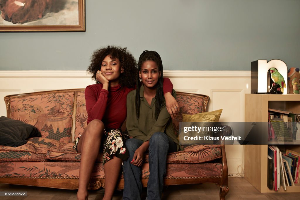 Two young women in sofa at home