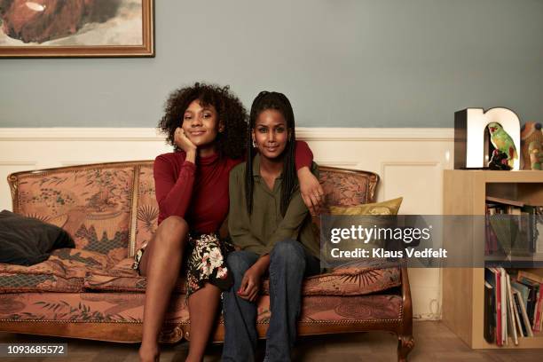 two young women in sofa at home - couple portrait fotografías e imágenes de stock