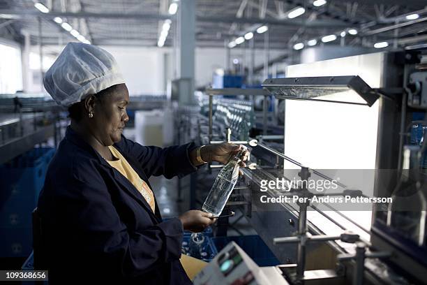 Woman checks bottles of mineral rich sparkling water as it is made in this factory who was established 80 years ago in Sekele locality near a hot...