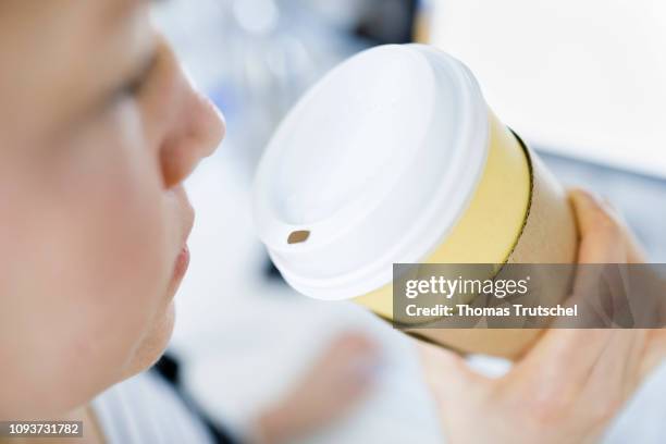 Berlin, Germany A woman drinks at her desk in the office from a disposable cup on February 04, 2019 in Berlin, Germany.