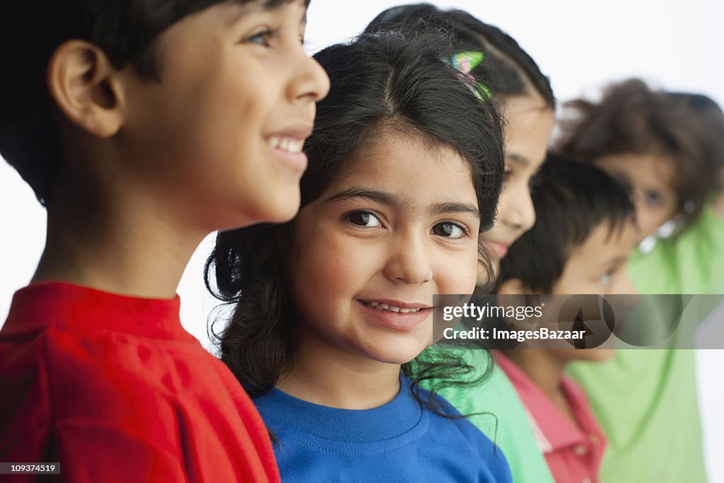 Cheerful boys (6-7) and girls (4-5) standing side by side