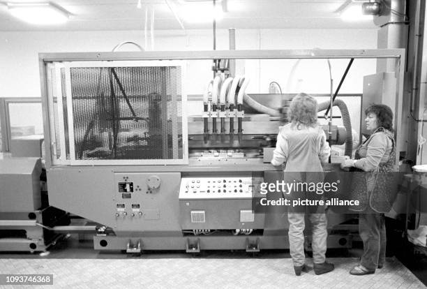 Zwei Arbeiterinnen an einer Siebdruckanlage, die für Erzeugnisse des VEB Berlin-Kosmetik das zweifarbige Dekor auf Deo-Roller oder...