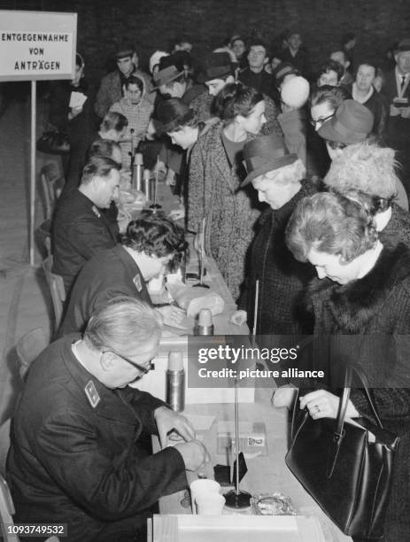 Original-Pressemeldung des DDR-Nachrichtendienstes ADN auf der Rückseite des Bildes: "Berlin : Passierscheinstelle pünktlich geöffnet - Pünktlich auf...