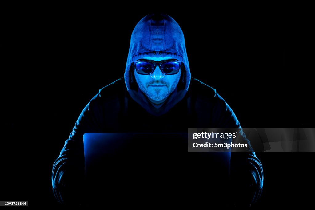 Hacker man with laptop stealing personal data from internet