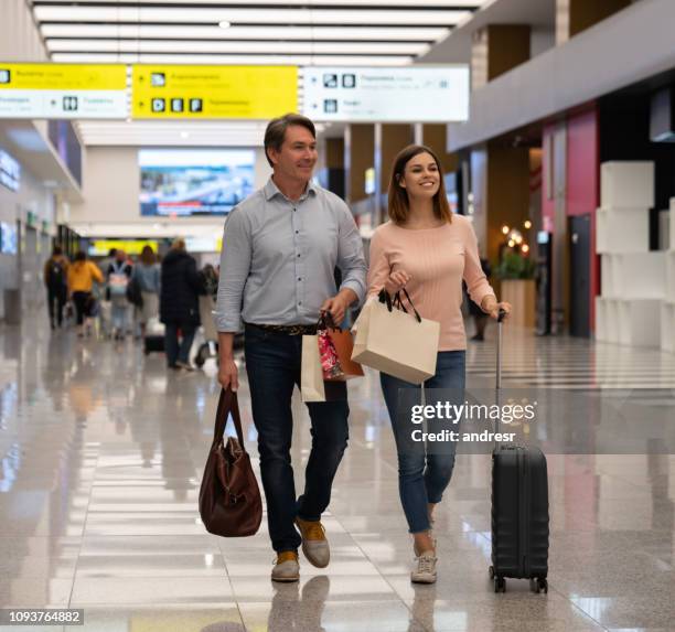 couple of travelers at the airport shopping at the duty free - tax free stock pictures, royalty-free photos & images