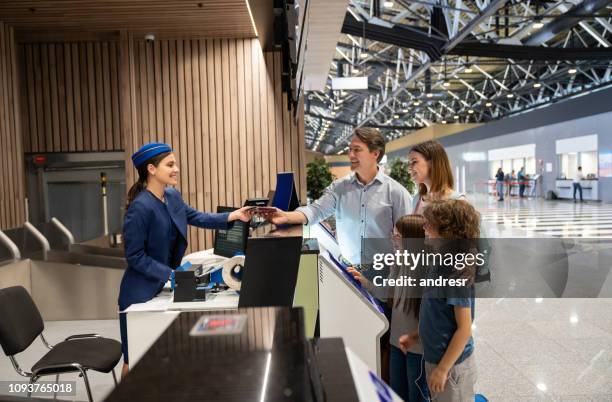 happy family traveling and doing the check-in at the airport - travel check in stock pictures, royalty-free photos & images