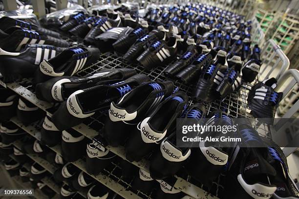 Handcrafted football boots stand in a rack at the factory of German sporting-goods maker Adidas AG on February 23, 2011 in Scheinfeld, Germany. The...