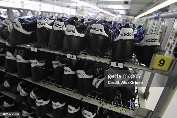 Handcrafted football boots stand in a rack at the factory of German sporting-goods maker Adidas AG on February 23, 2011 in Scheinfeld, Germany. The...