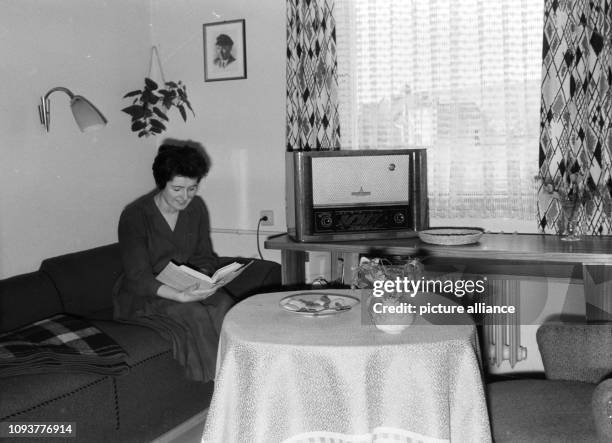 Einweihung des neuen Schwesternwohnheims der Friedrich-Schiller-Universität Jena. Eine junge Frau liest auf einem Sofa sitzen ein Buch. Zur...