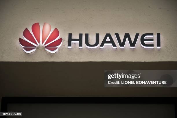Picture taken on February 4, 2019 shows the Huawei logo above the entrance of a Huawei store in Paris. - A government amendment to establish a...