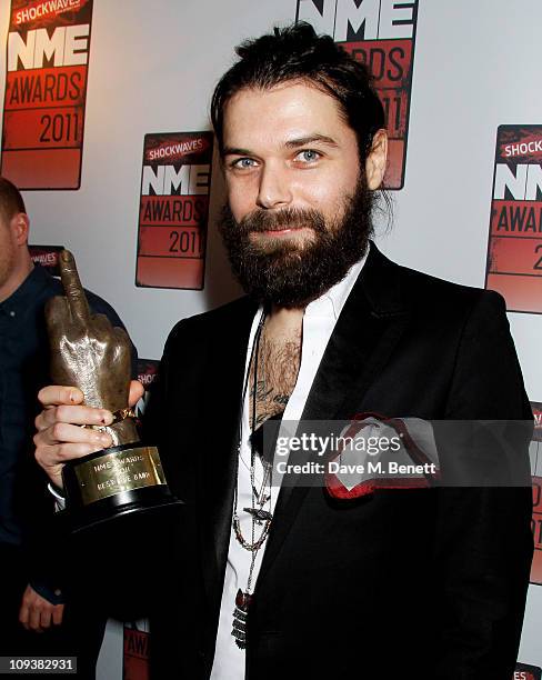 Simon Neil of Biffy Clyro poses against the Shockwaves NME Awards 2011 winners boards with their award for 'Best Live Band' at Brixton Academy on...