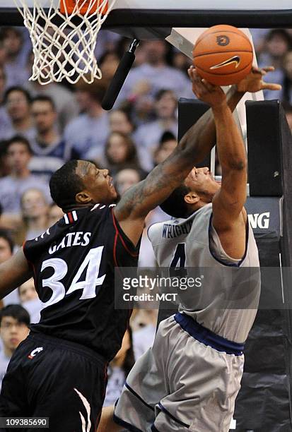 Cincinnati forward Yancy Gates defends a shot attempt by Georgetown guard Chris Wright during first-half action at the Verizon Center in Washington,...