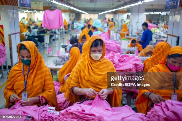 Garments workers are seen working in a sewing and finishing section. Garments industry in Bangladesh drive the economy growth and it is now the major...