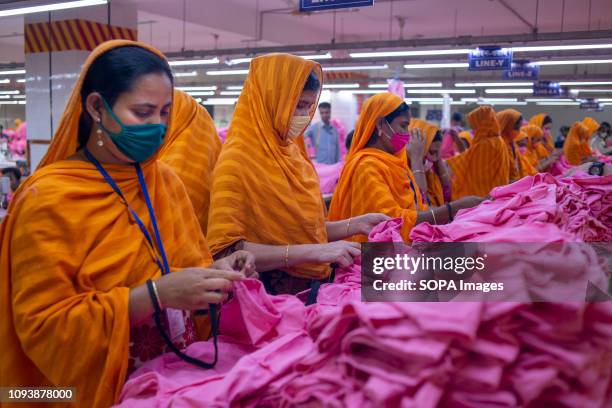 Garments workers are seen working in a sewing and finishing section. Garments industry in Bangladesh drive the economy growth and it is now the major...