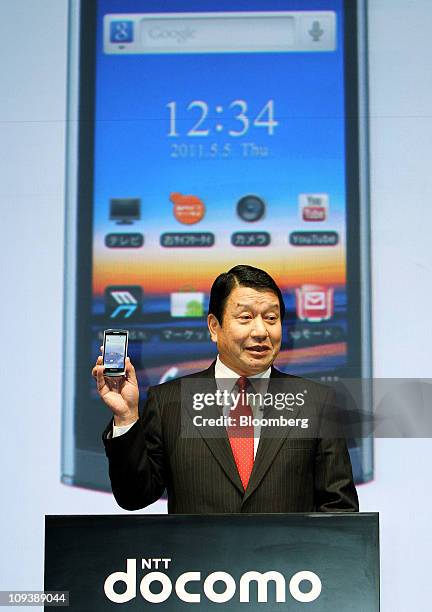 Ryuji Yamada, president and chief executive officer of NTT DoCoMo Inc., shows the Medias smartphone, manufactured by NEC Casio Mobile Communications...