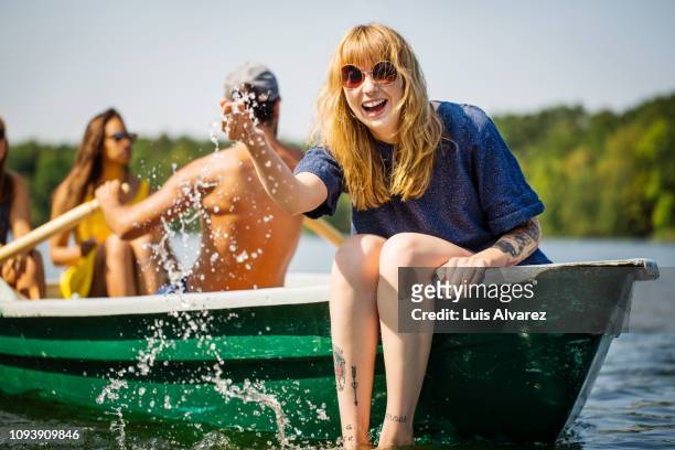 woman enjoying boat ride in lake - boat in lake stockfoto's en -beelden