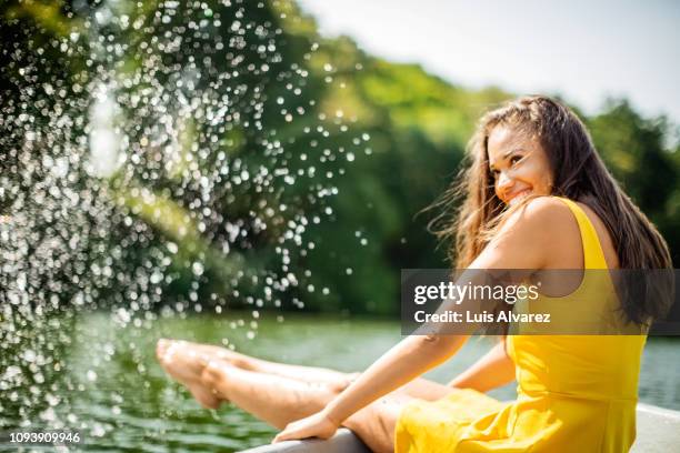 woman having fun on boat ride in lake - yellow dress - fotografias e filmes do acervo