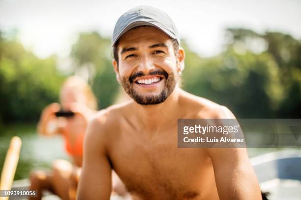 young man on a row boat - oberkörperaufnahme stock-fotos und bilder
