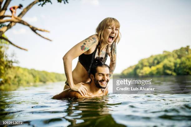 young couple having fun at the lake - junger erwachsener stock-fotos und bilder