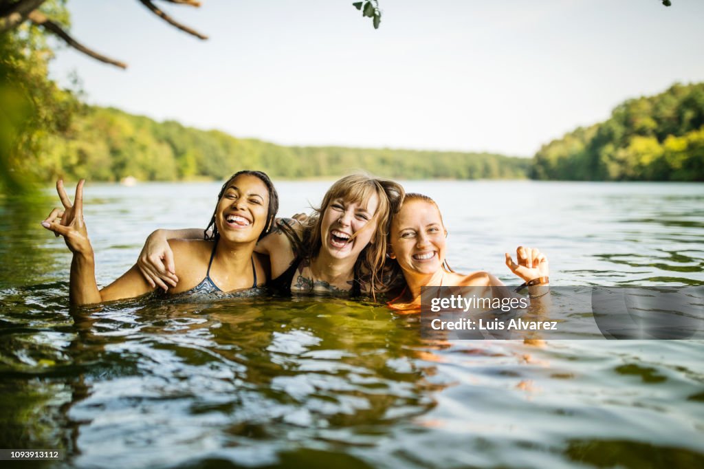 Portrait of three young women together in lake