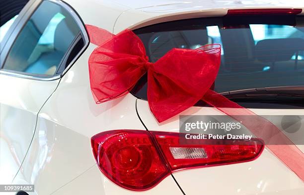 new car with red ribbon and red bow - auto nuevo fotografías e imágenes de stock