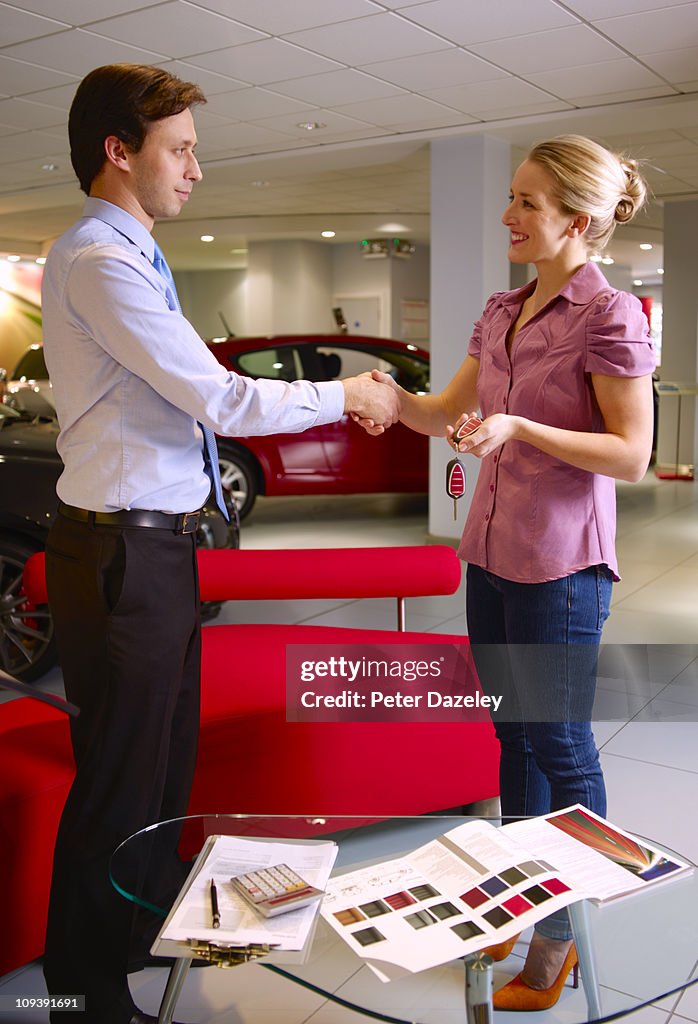 Salesman does the deal in car showroom