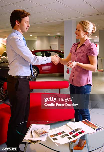 salesman does the deal in car showroom - sold engels woord stockfoto's en -beelden