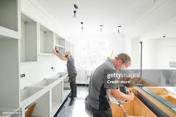 schrijnwerkerij-team een keuken montage - kitchen cupboard stockfoto's en -beelden