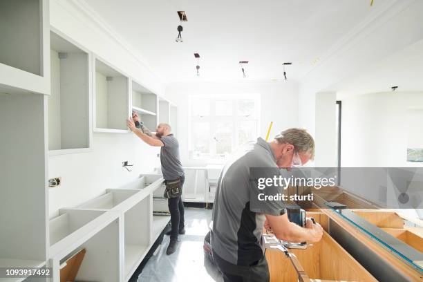 joinery team fitting a kitchen - installing new kitchen stock pictures, royalty-free photos & images
