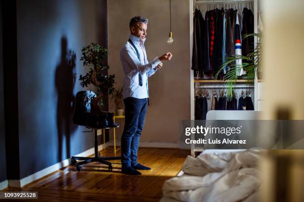 mid adult man getting ready for office - man wardrobe stock pictures, royalty-free photos & images