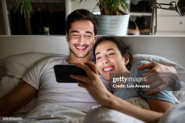 couple watching movie on smartphone in bed - couple watching a movie bildbanksfoton och bilder