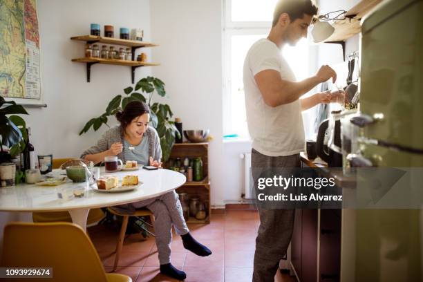 young couple in kitchen in morning - mann kocht stock-fotos und bilder