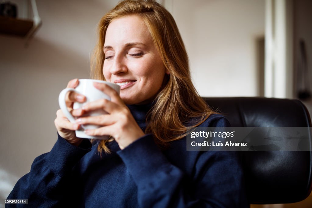 Woman enjoying having coffee at home