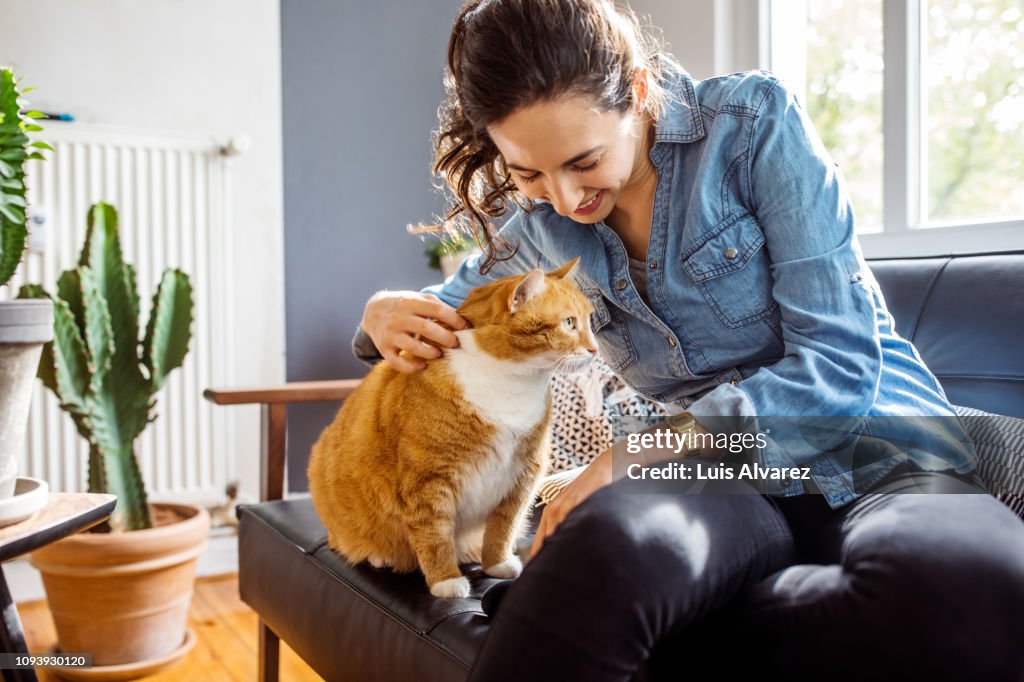 Woman playing with her cat at home