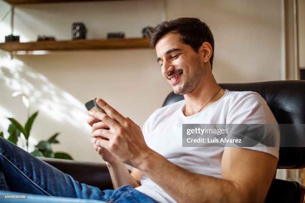 Young man using smart phone at home