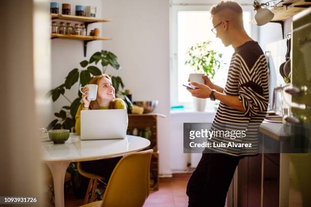 couple talking over a coffee at home - frau offenes lächeln küche stock-fotos und bilder