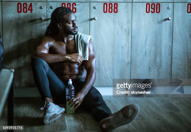 pensive african american athlete resting at gym's locker room. - mens changing room stock pictures, royalty-free photos & images