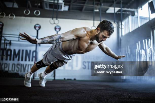muscular build athlete having training in a gym. - bodyweight training stock pictures, royalty-free photos & images