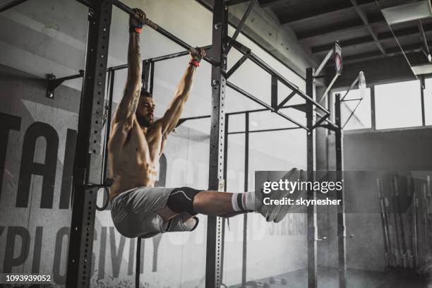 jonge gespierde bouw atleet uit te oefenen kracht in een sportschool. - chin ups stockfoto's en -beelden