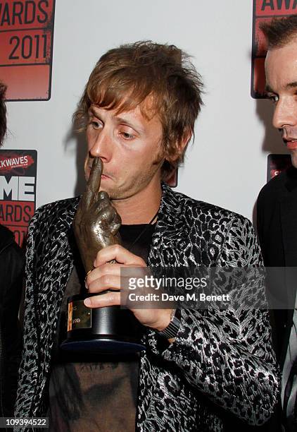 Dominic Howard of the band Muse poses with the "Best British Band award supported by Shockwaves" in front of the winners boards at the Shockwaves NME...