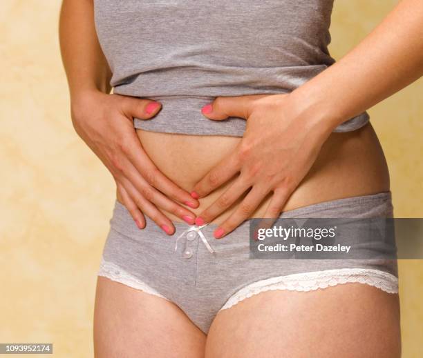 woman with bloated tummy, close up - swollen fotografías e imágenes de stock