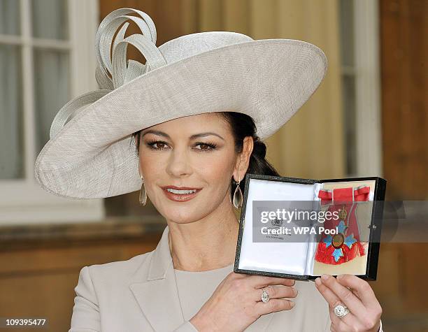 Actress Catherine Zeta Jones poses after she was made a Commander of the British Empire by the Prince of Wales at Buckingham Palace on February 24,...