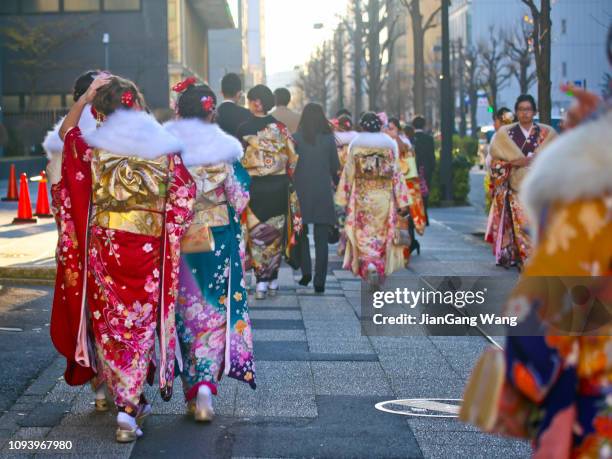 japoneses nuevos adultos usar kimonos y trajes 'que viene de edad día' en la calle de yokohama - seijin no hi fotografías e imágenes de stock