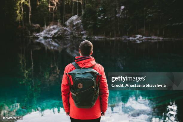 homem com mochila andando no lago blausee, na suíça - mitholz - fotografias e filmes do acervo