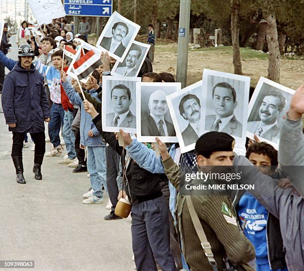 Jordanian supporters hold placards of Arab leaders Iraqi President Saddam Hussein, Egyptian President Hosni Mubarak, Jordanian King Hussein and North...