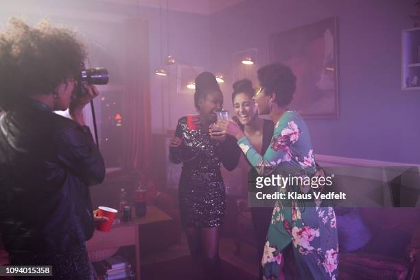 young woman photographing her friends dancing - fashion photographer stock pictures, royalty-free photos & images