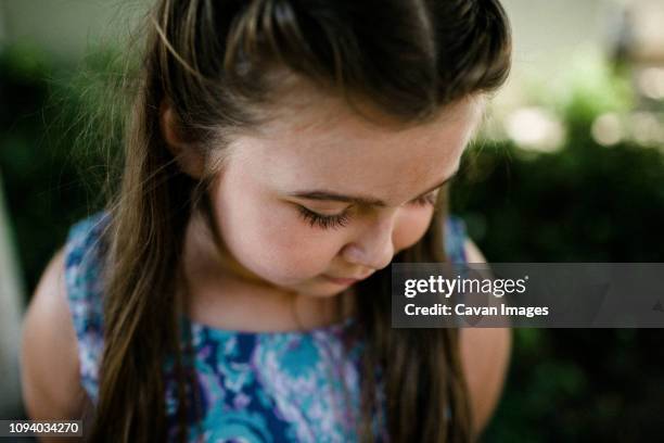 high angle view of cute girl standing at park - chubby girls photos fotografías e imágenes de stock