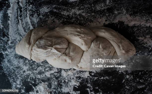 overhead view of braided bread dough with flour on table at home - braided bread stock pictures, royalty-free photos & images