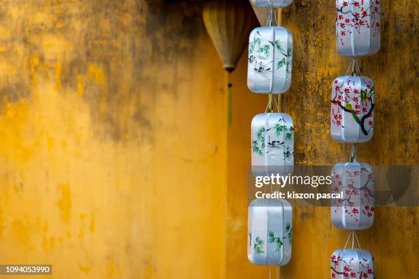 paper lanterns in a street of the old town of hoi an in vietnam . - vietnam wall stock pictures, royalty-free photos & images