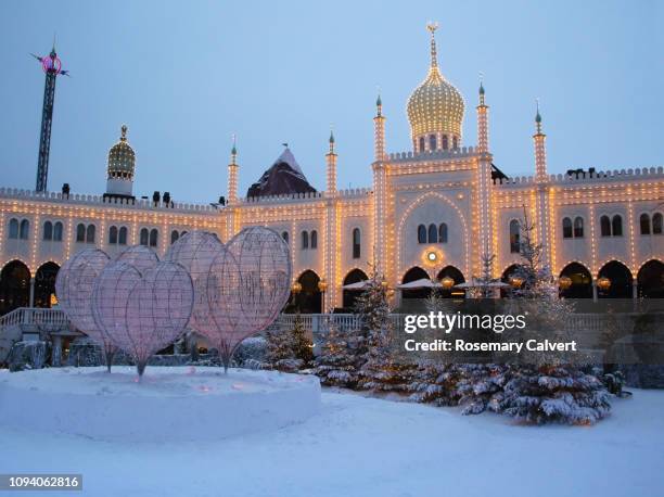 tivoli gardens nimb hotel lit up at dusk, copenhagen. - tivoli copenhagen stock pictures, royalty-free photos & images